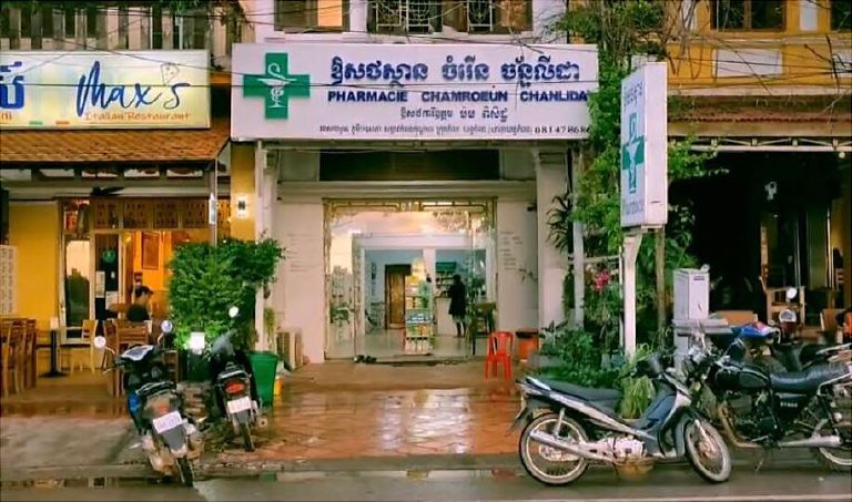 Une pharmacie dans une rue de Kampot, croix verte au-dessus de l'entrée