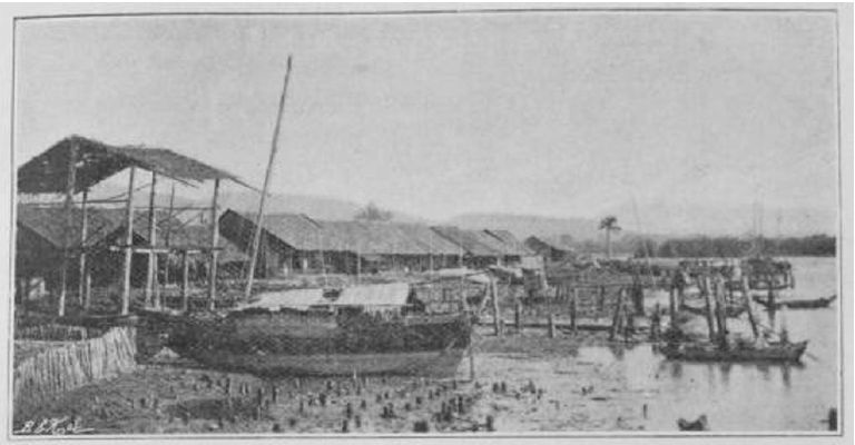 Kampot riverfront in the 1880s, with wooden buildings, piers, and boats along the water