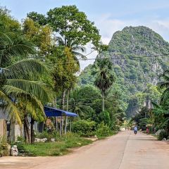 A karst hill rising over a quiet countryside road near Kampot