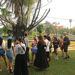 A guided group gathered at a riverside shrine in Kampot
